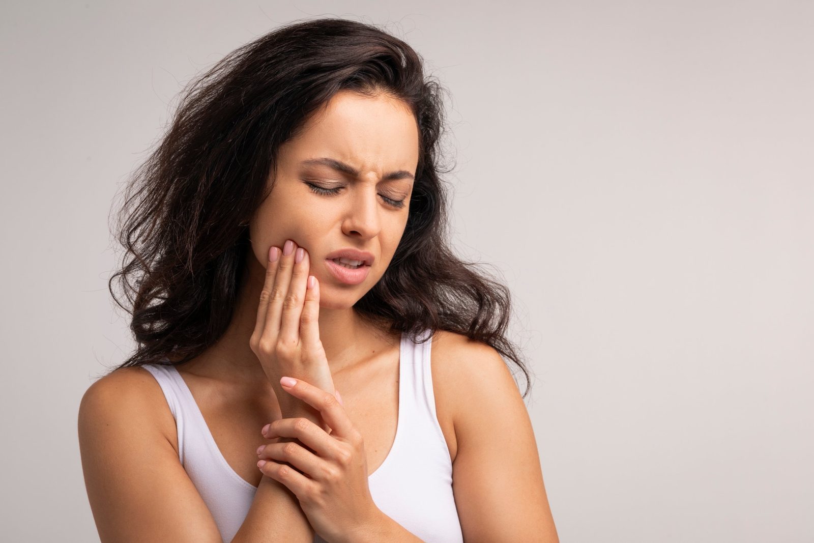 A woman holding her jaw with a severe toothache